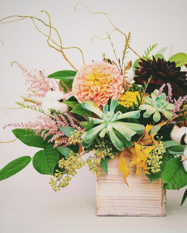 Centro de dalias, suculentas y astilbe en una caja de madera